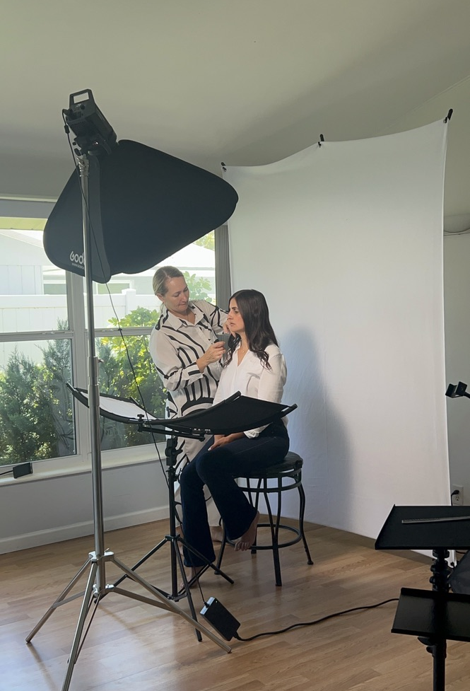 Kate styling a client in front of the backdrop during a studio photo session